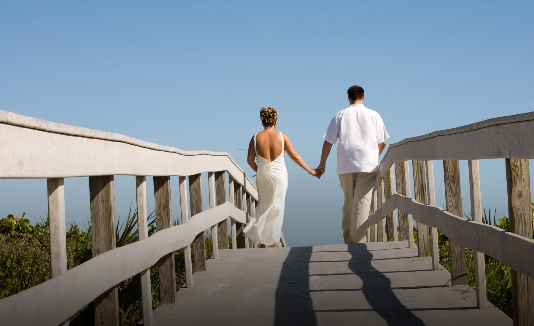 couple holding hands on boardwalk